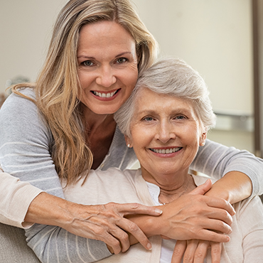 A young woman embracing an elderly woman, showing love and affection in a heartwarming moment of connection.