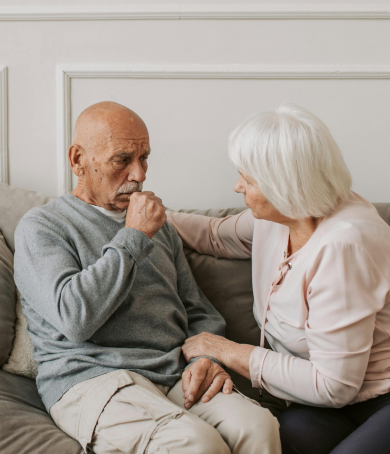 Senior woman comforting elderly man on couch with Healthcare Services logo, promoting compassionate elderly care and support services